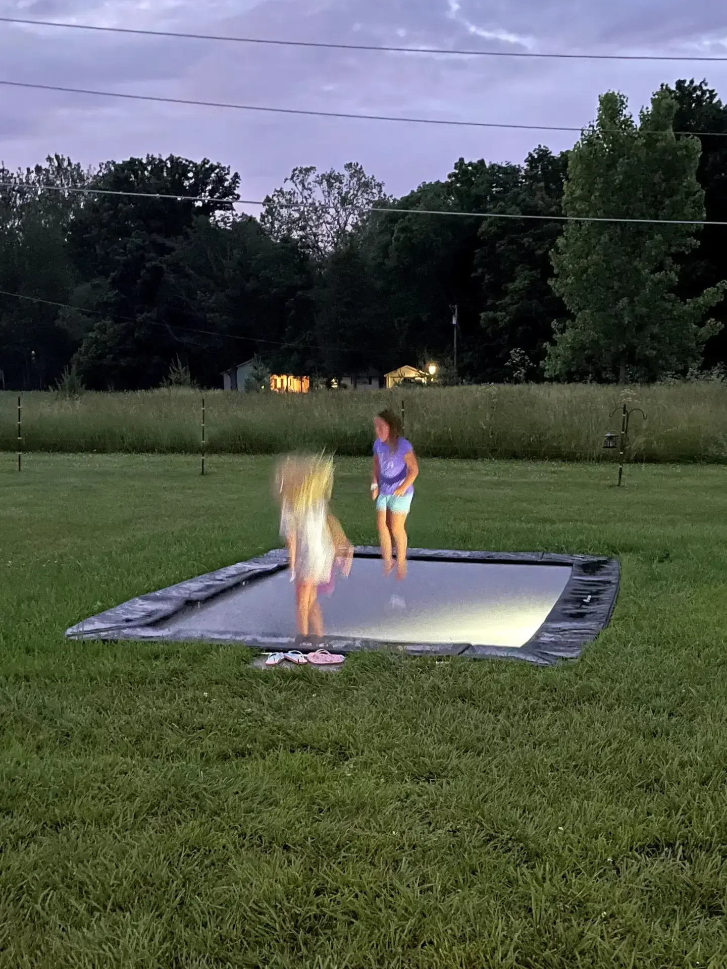 children playing on a black rectangular inground trampoline
